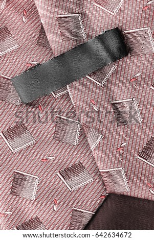 Black blank clothes label on pink cloth as a background