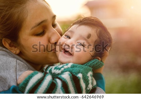 Young Indian mother kissing her beloved baby