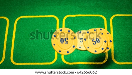 Poker chips in the fall against the background of a green playing field for poker