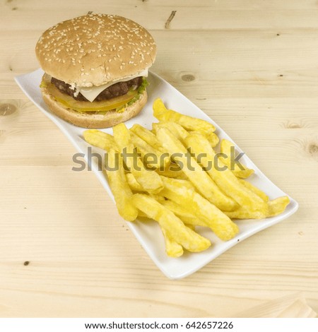 Burger and chips on wooden background
