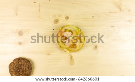 Making burger and chips on wooden background - top view