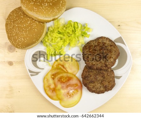 Hamburgers in a plate on wooden background - top view