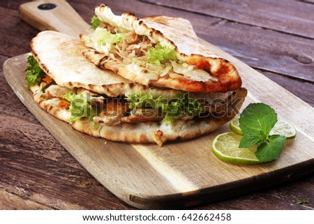 Delicious kebab sandwiches on brown wooden table