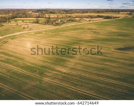 drone image. aerial view of rural area with freshly cultivated fields in sunny spring day. latvia - vintage look film effect