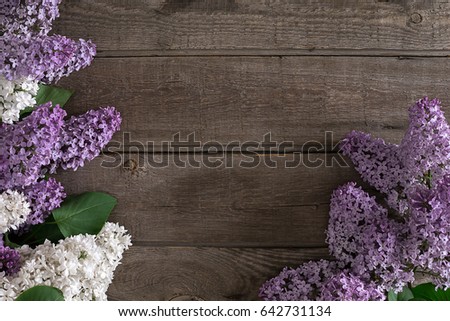 Lilac blossom on rustic wooden background with empty space for greeting message. Top view