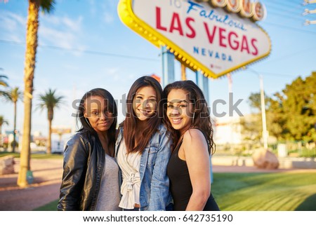 three girl friends in front of welcome to las vegas sign