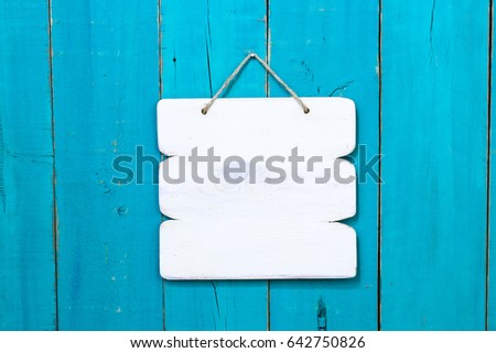 Blank wood white sign hanging by rope on antique rustic teal blue wooden background; painted background with copy space