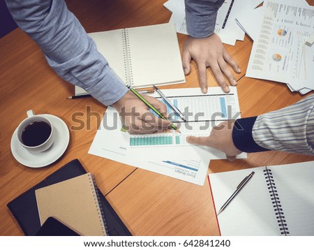 Businessmen discussing project in meeting room, over time