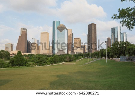 Downtown Houston at sunset with people exercising in distant. Green park lawn and modern skylines. The most populous city in Texas, and fourth-most in United States. Architecture and travel background