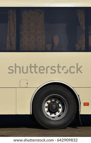 Photo of the hull of a large and long yellow bus with free space for advertising. Close-up side view of a passenger vehicle for transportation and tourism