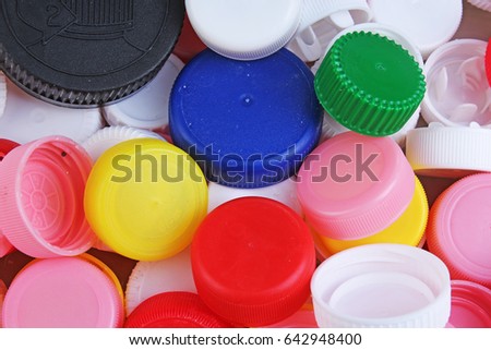 Collect plastic bottle caps. 
Close-up shot of stack of recyclable plastic bottle caps on white background. Bottle cap texture pattern as background.