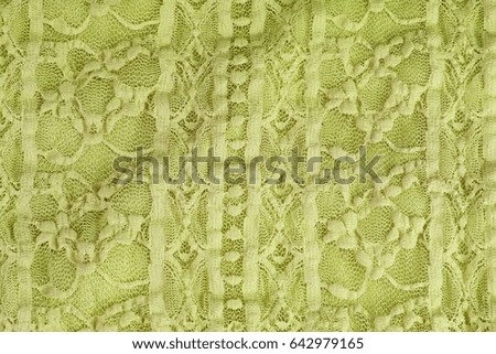 Green Crochet lace dress material cloth texture pattern. 
tailoring stitching concept. Shiny beautiful fashion fabric. Shiny clothing material sample.Creased fabric.