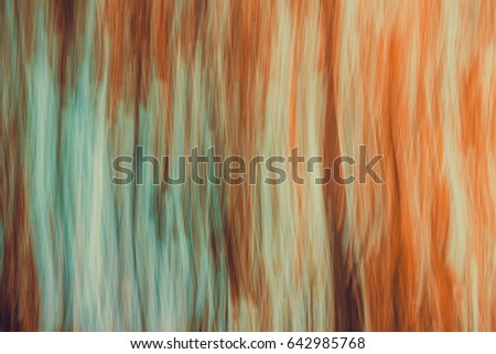 Abstract blurred landscape with movement effect in orange and blue colors.  Background with directional blur, motion effect and long exposure. Vertical lines and strips.