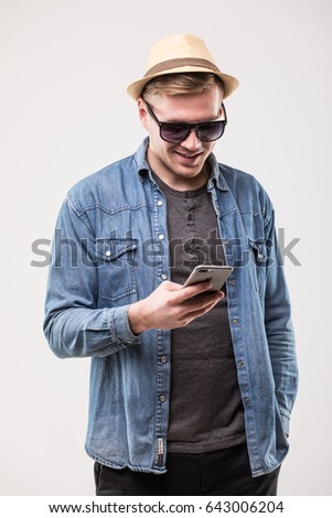 Profile view of happy young man smiling while using mobile phone