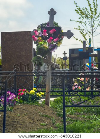 Grave with a cross and a fence in an old cemetery