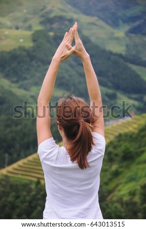 women practice yoga on top of the mountain in nature