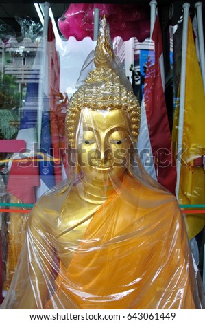 Buddha statue wrapped in cellophane on a market in Thailand