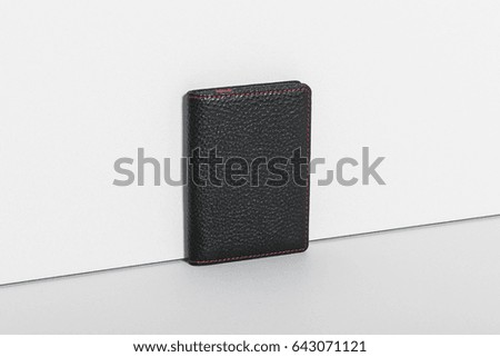 a black leather wallet on the grey background.