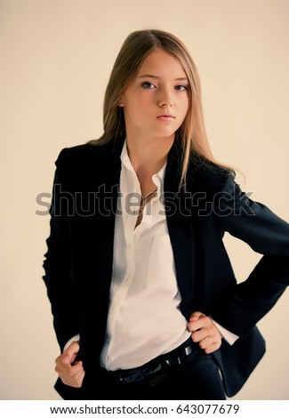 Girl in a dark suit on a light background portrait
