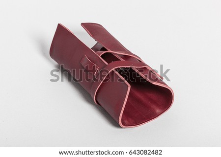 red leather pencil pocket on the grey background.