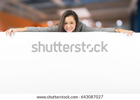 Woman smiling showing white blank sign billboard