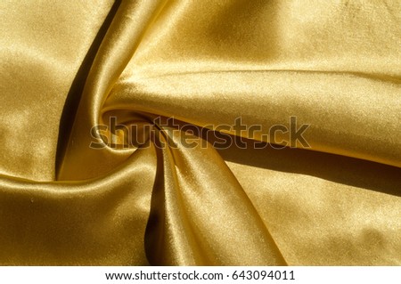 Texture, fabric, background. Abstract background of luxurious fabric or liquid waves or wavy grunge crease silk satin texture of velvet material or luxurious Christmas or elegant background. gold