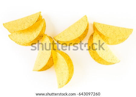 Yellow corn taco shells on a white background.