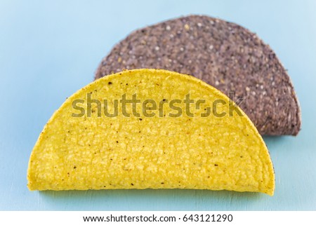 Blue and yellow corn taco shells on a blue background.
