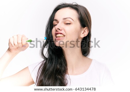 Woman brushing her teeth, light background