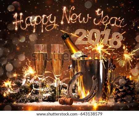 New Years Eve celebration background with pair of flutes and bottle of champagne in bucket and a horseshoe as lucky charm Royalty-Free Stock Photo #643138579