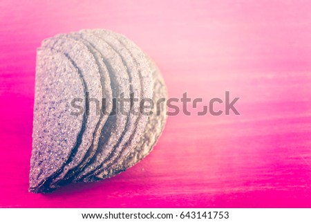 Blue corn taco shells on a pink background.