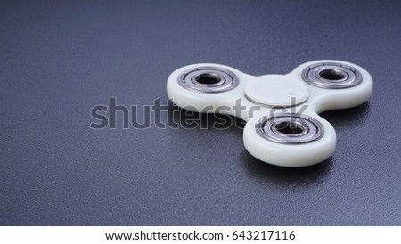 Fidget finger spinner stress, anxiety relief toy on white background. Selective focus.
