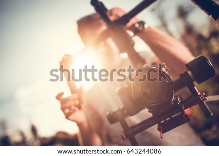 Camera Gimbal DSLR Video Production. Pro Video Stabilization. Video Maker Taking Shoots Using Pro Equipment. Royalty-Free Stock Photo #643244086