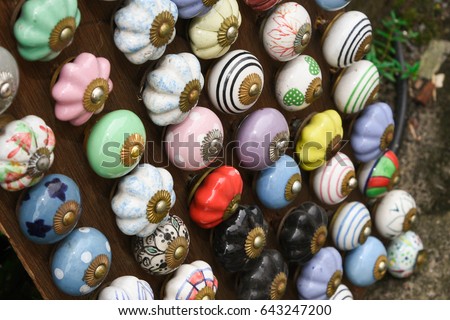 Painted colorful, beautiful collection of ethnic door Knob selling by street vendor, Jaipur, Rajasthan India. Vintage Indian handicraft in a shop for sale. brass, glass and ceramic door handles. Royalty-Free Stock Photo #643247200