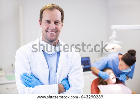 Portrait of dentist standing with arms crossed in clinic Royalty-Free Stock Photo #643290289