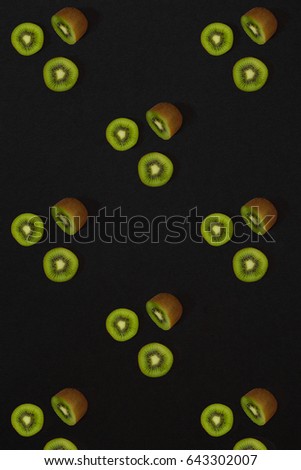 Pattern of kiwi. Top view of the sliced kiwi on black background. Minimal flat lay concept.