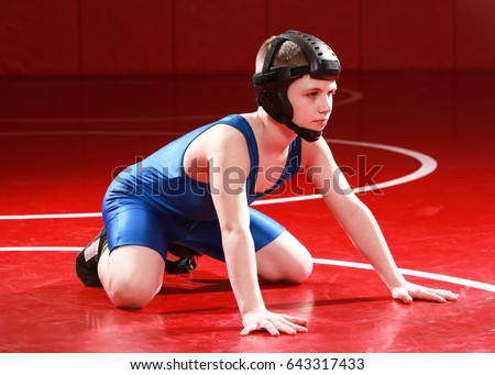 Youth wrestler in blue singlet starting in the down position