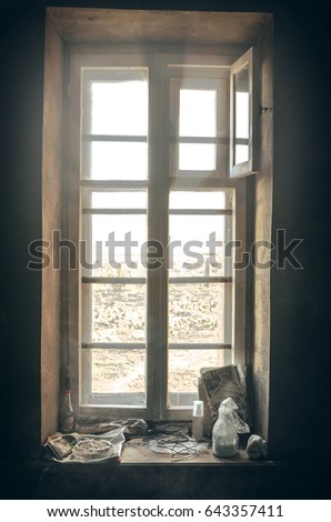 Grained photo of aged rural window. Light through the window.