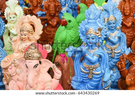 Many colorful statue / sculptures of Hindu god, lord Krishna playing flute in an street shop, Delhi, India. popular Indian divinity worshiped incarnation of Vishnu. birth celebrated as Janmashtami .  Royalty-Free Stock Photo #643430269