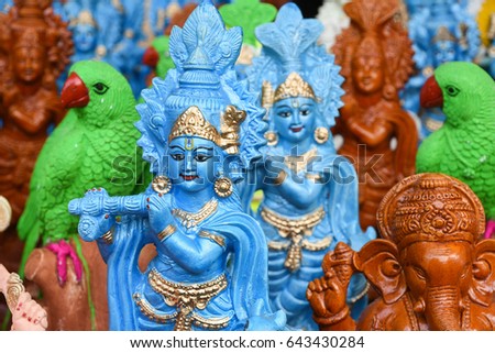 Many colorful statue / sculptures of Hindu god, lord Krishna playing flute in an street shop, Delhi, India. popular Indian divinity worshiped incarnation of Vishnu. birth celebrated as Janmashtami .  Royalty-Free Stock Photo #643430284