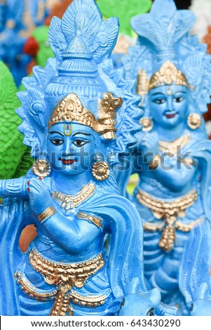 Many colorful statue / sculptures of Hindu god, lord Krishna playing flute in an street shop, Delhi, India. popular Indian divinity worshiped incarnation of Vishnu. birth celebrated as Janmashtami .  Royalty-Free Stock Photo #643430290