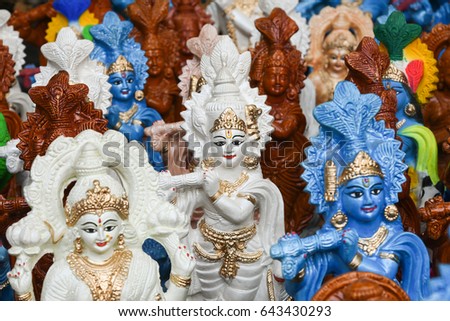 Many colorful statue / sculptures of Hindu god, lord Krishna playing flute in an street shop, Delhi, India. popular Indian divinity worshiped incarnation of Vishnu. birth celebrated as Janmashtami .  Royalty-Free Stock Photo #643430293