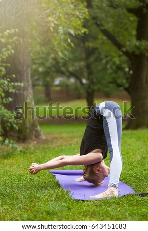 Young yoga girl doing yoga outdoors, doing asanas