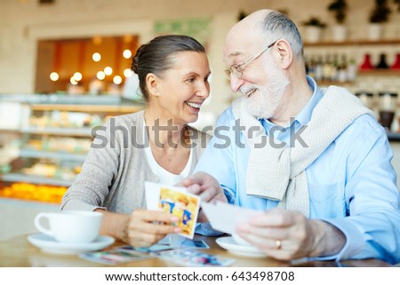 Senior couple looking through photos in cafe