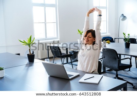 Smiling woman, living day, spare time in the office. Royalty-Free Stock Photo #643512808