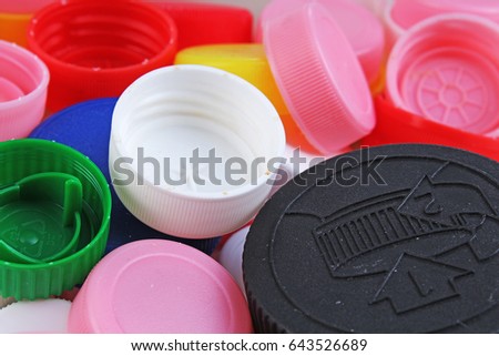 Collect plastic bottle caps. 
Close-up shot of stack of recyclable plastic bottle caps on white background. Bottle cap texture pattern as background.

