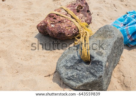 Anchor stones, a photograph of two gadgets with a hole and a usual banded rope, are used in India by fishermen for boats and schooners.