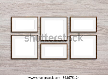 Six brown photo frames set on wooden panels wall