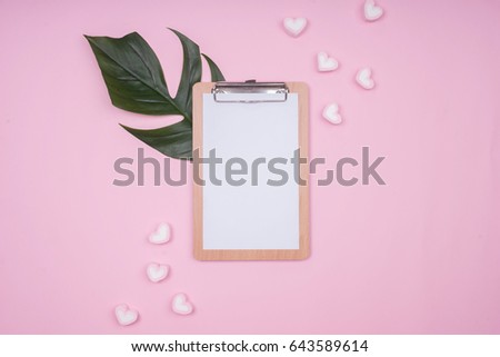 Feminine Style Mock-up with clipboard, palm leaf and sweet marshmallow. Flat lay, top view on pink background.