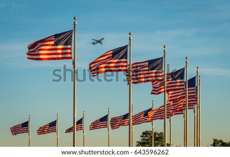 Plane above the flags around Washington Monument in Washington DC